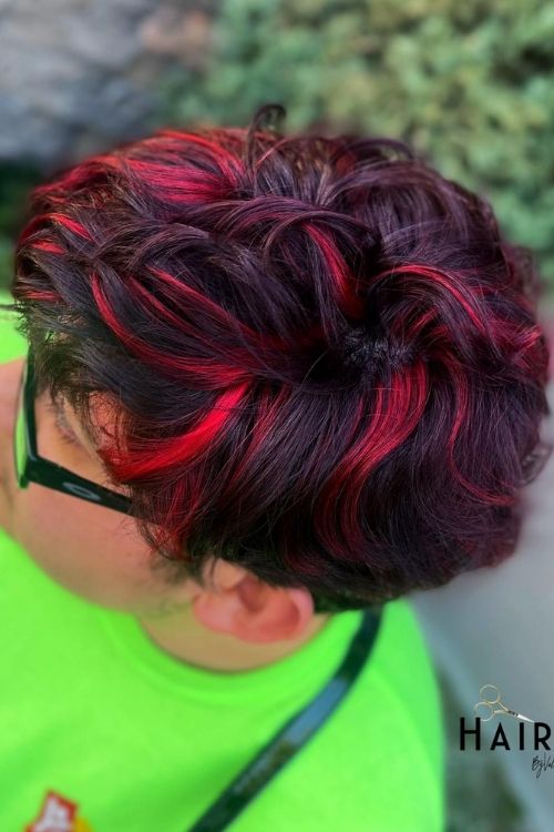 Curly dark hair with red streak highlights