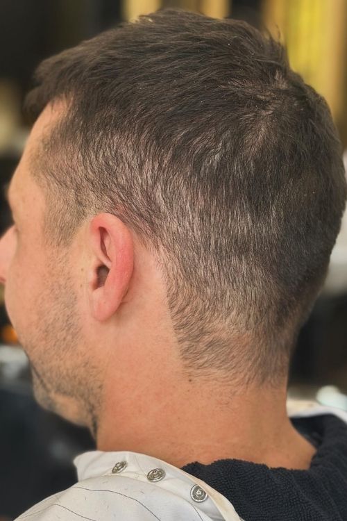 Dark brown close-cropped buzz cut with a tapered fade