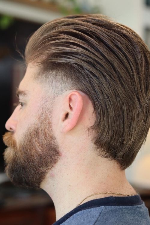 Light brown slicked back undercut with natural volume taper fade.