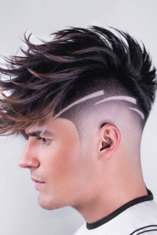 Textured faux hawk with high skin fade featuring sharp line design with brown highlights.